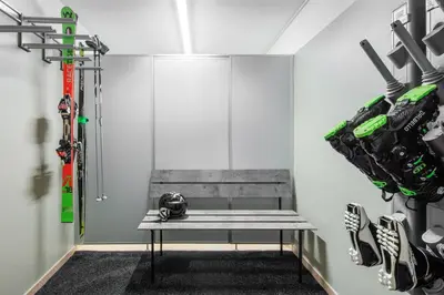 a bench in a room with skis and ski equipment at DACIASA Apartment in San Vigilio Di Marebbe