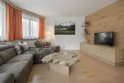 a living room with a couch and a tv at DACIASA Apartment in San Vigilio Di Marebbe
