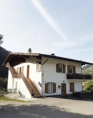 a white house with stairs on the side of it at Vacanzemoena - Casa al Parco, tipologia 1 in Moena