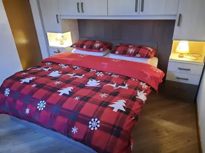 a bedroom with two beds and a red blanket at Vacanzemoena - Casa al Parco, tipologia 1 in Moena