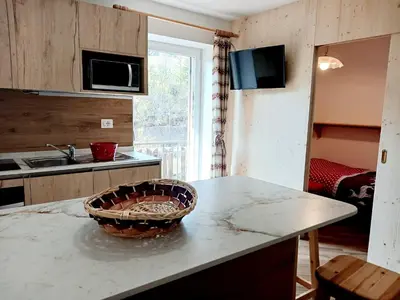 a kitchen with a counter with a basket on it at Vacanzemoena - Casa al Parco, tipologia 1 in Moena
