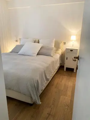 a bedroom with a white bed with a nightstand and a bed sidx sidx sidx at Appartamento San Pellegrino in Passo San Pellegrino