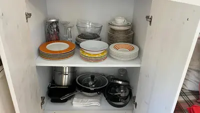 a cupboard filled with plates and bowls and dishes at Appartamento San Pellegrino in Passo San Pellegrino