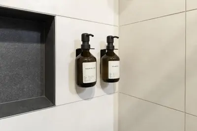 two bottles of wine hanging on a wall in a bathroom at Nina • Parchi e Fiume in Bressanone
