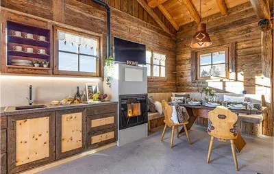 a kitchen with wooden walls and a table and a stove at Chalet Luisa in Predazzo