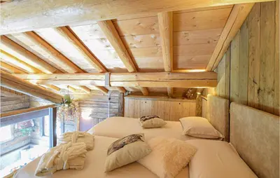 a bedroom with two beds in a room with wooden ceilings at Chalet Luisa in Predazzo