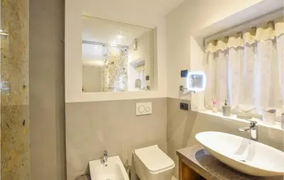 a bathroom with a sink and a toilet and a mirror at Chalet Luisa in Predazzo
