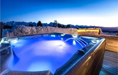 a jacuzzi tub with a view of the mountains at Chalet Luisa in Predazzo