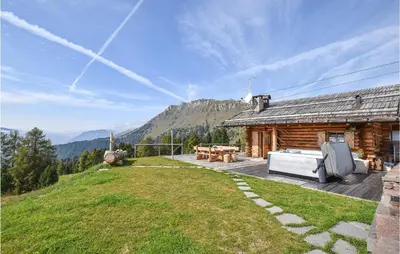 a log cabin on a hill with a patio at Chalet Luisa in Predazzo