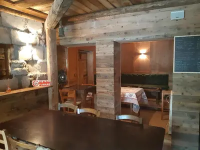 a dining room with a table and a bed at Locanda Rondolost in Cencenighe