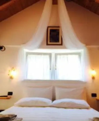 a bedroom with a window and a white bed at Locanda Rondolost in Cencenighe
