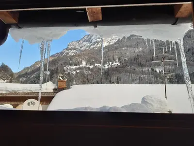 a view of a mountain from a window with icicles at Locanda Rondolost in Cencenighe