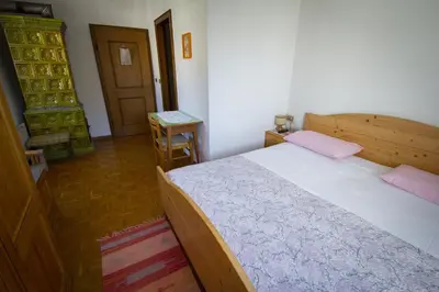 a bedroom with a bed with pink pillows on it at Albergo Stella in Cavalese