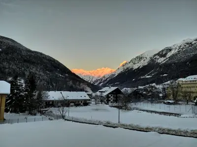 a village covered in snow with mountains in the background at Apartments Ban Guggugg in Colle Isarco