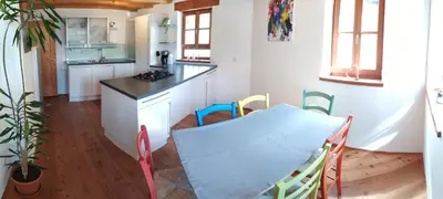 a kitchen with a table and chairs in a room at Apartments Ban Guggugg in Colle Isarco