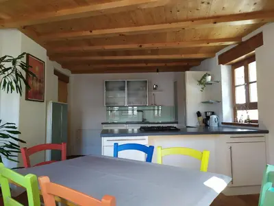 a kitchen with a table with colorful chairs at Apartments Ban Guggugg in Colle Isarco