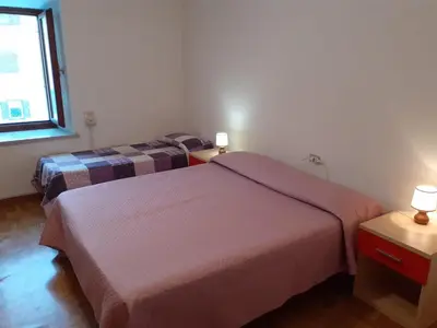 a hotel room with two beds and a window at Vacanzemoena - Casa del Moro in Moena