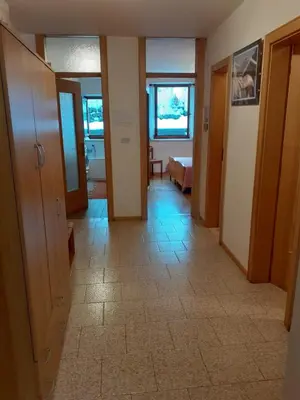 a hallway with doors and a tile floor at Vacanzemoena - Casa del Moro in Moena