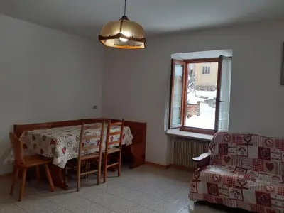 a dining room with a table and a chair at Vacanzemoena - Casa del Moro in Moena