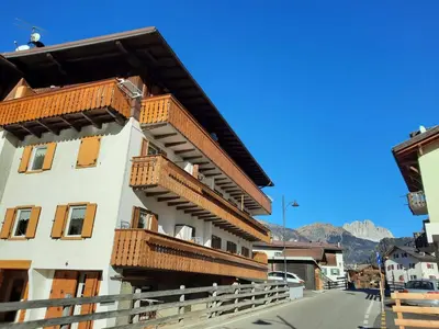 a building with wooden balconies on the side of it at Appartamento Casa Montagna Lory in Pozza di Fassa
