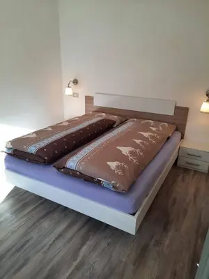 a bed with two brown comforters on top of it at Appartamento Casa Montagna Lory in Pozza di Fassa