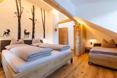 a bedroom with two beds and trees on the wall at Appartments zum Beck in Eggen