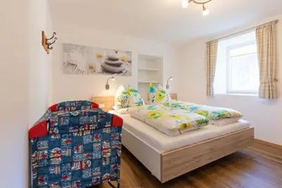 a white bedroom with a bed and a window at Appartments zum Beck in Eggen