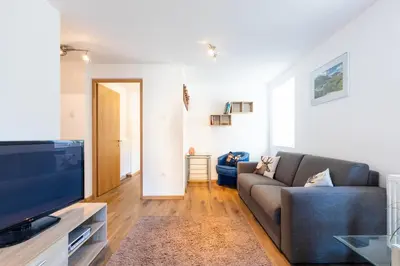 a living room with a couch and a tv at Appartments zum Beck in Eggen