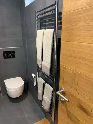 a bathroom with a toilet and towels on a door at San Vigilio di Marebbe - Suite di Montagna in San Vigilio Di Marebbe
