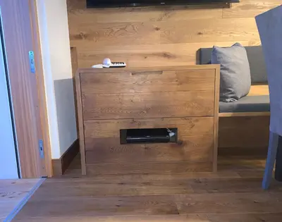 a room with a bed with a wooden wall with a drawer at San Vigilio di Marebbe - Suite di Montagna in San Vigilio Di Marebbe