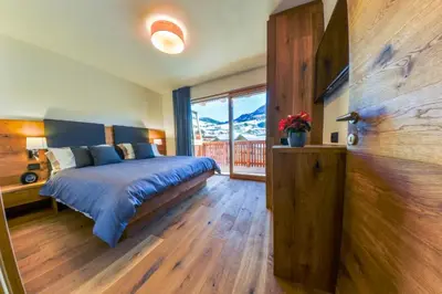 a bedroom with a bed and a large window at San Vigilio di Marebbe - Suite di Montagna in San Vigilio Di Marebbe