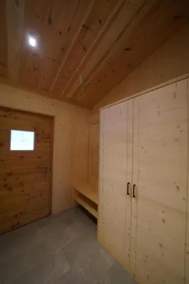 a large room with wooden cabinets and a door at NEUE Ferienwohnungen auf dem Gebreitnerhof, Urlaub auf dem Bauernhof in Bressanone