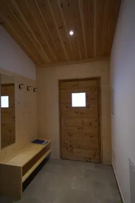 a room with a wooden door and a room with a bench at NEUE Ferienwohnungen auf dem Gebreitnerhof, Urlaub auf dem Bauernhof in Bressanone