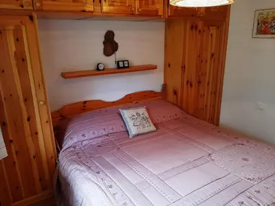 a bedroom with a wooden bed in a room with a window at Vacanzemoena - Cielo Azzurro, tipologia 4 in Moena