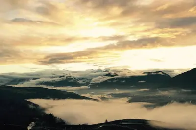 a view of clouds and mountains with the sun setting at Residence Bellavista in Fondo