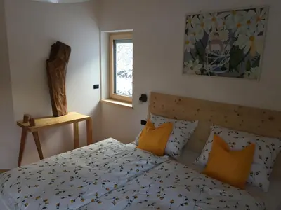 a bedroom with a bed with orange pillows and a window at Cësa Gredine in Ortisei