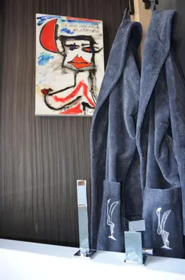 a pair of denim jackets on a shelf with a painting at Locanda degli Artisti Art Hotel in Canazei