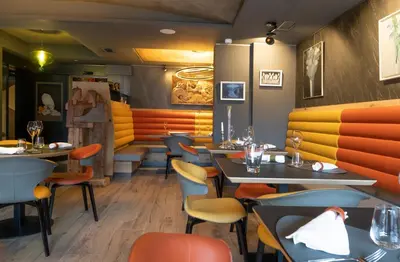 a restaurant with tables and chairs in a room at Locanda degli Artisti Art Hotel in Canazei