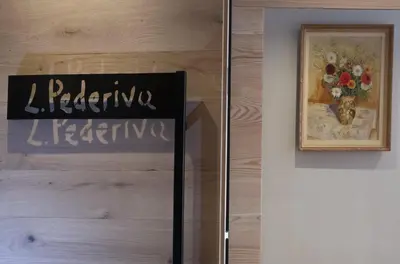 a sign on a wall with a picture of flowers at Locanda degli Artisti Art Hotel in Canazei
