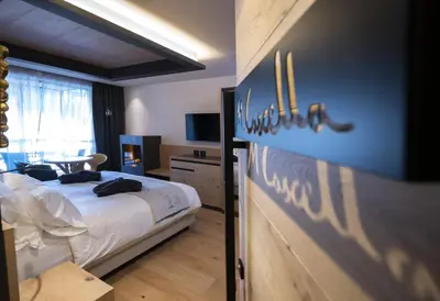 a bedroom with a bed and a table in it at Locanda degli Artisti Art Hotel in Canazei