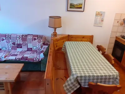 a room with a bed and a table and a bed and a desk at Vacanzemoena - Cielo Azzurro, tipologia 1 in Moena