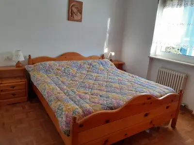 a bed with a quilt on it in a bedroom at Vacanzemoena - Cielo Azzurro, tipologia 1 in Moena