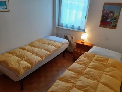 a bedroom with two beds and a lamp on a table at Vacanzemoena - Cielo Azzurro, tipologia 1 in Moena
