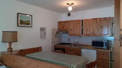 a kitchen with wooden cabinets and a counter top at Vacanzemoena - Cielo Azzurro, tipologia 1 in Moena