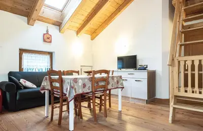 a kitchen and dining room with a table and chairs at Mansarda 4 posti letto in Villa a Borca di Cadore in Villanova