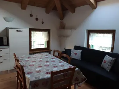 a living room with a table and a blue couch at Mansarda 4 posti letto in Villa a Borca di Cadore in Villanova