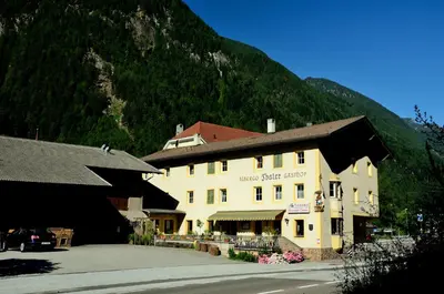 a large building in front of a mountain at Gasthof Thaler in Mezzaselva