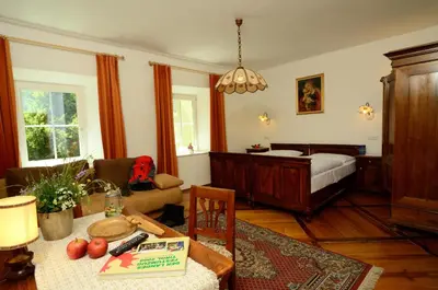a living room with a bed and a table at Gasthof Thaler in Mezzaselva