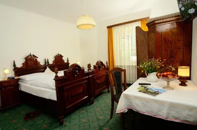 a bedroom with two beds and a table with a table sidx sidx at Gasthof Thaler in Mezzaselva