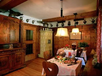a dining room with a table with flowers on it at Gasthof Thaler in Mezzaselva